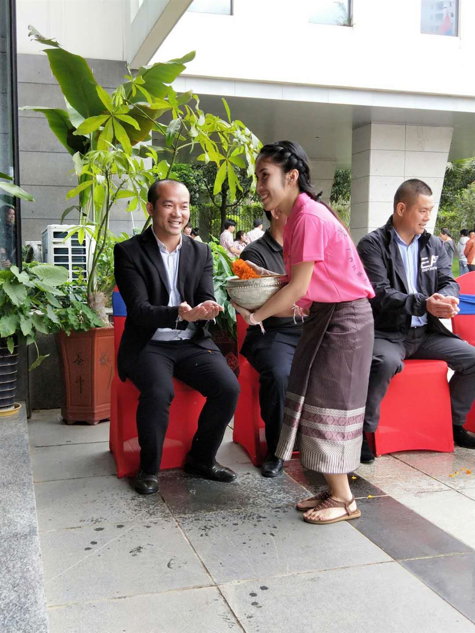 老撾駐廣西留學(xué)生代表將浸有花瓣的香水灑客人的手上，表示對嘉賓的美好祝福（圖一）