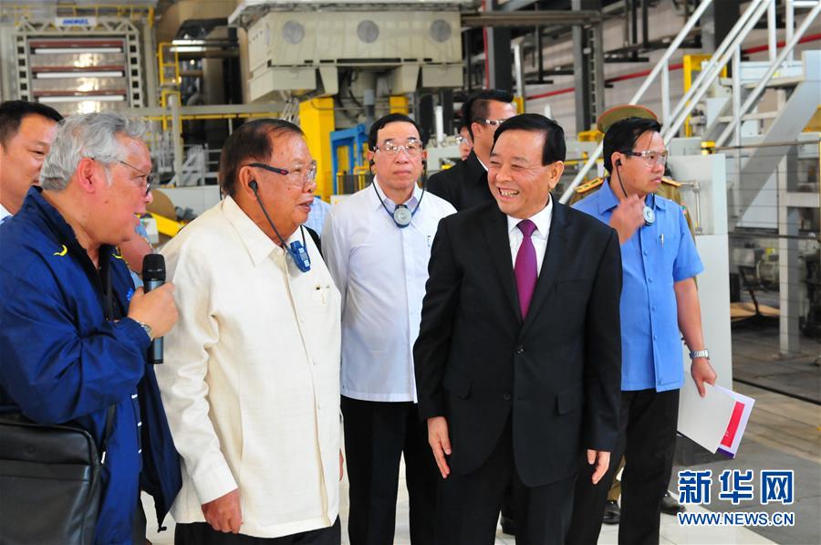 3月10日，在老撾沙灣拿吉省車邦縣，老撾人民革命黨中央總書記、國家主席本揚（左二）在山東太陽紙業(yè)股份有限公司董事長李洪信（右二）的陪同下視察公司。 新華社記者章建華攝